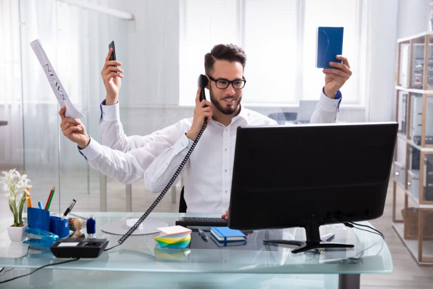 Smiling,Young,Businessman,Doing,Multitasking,Work,At,Workplace